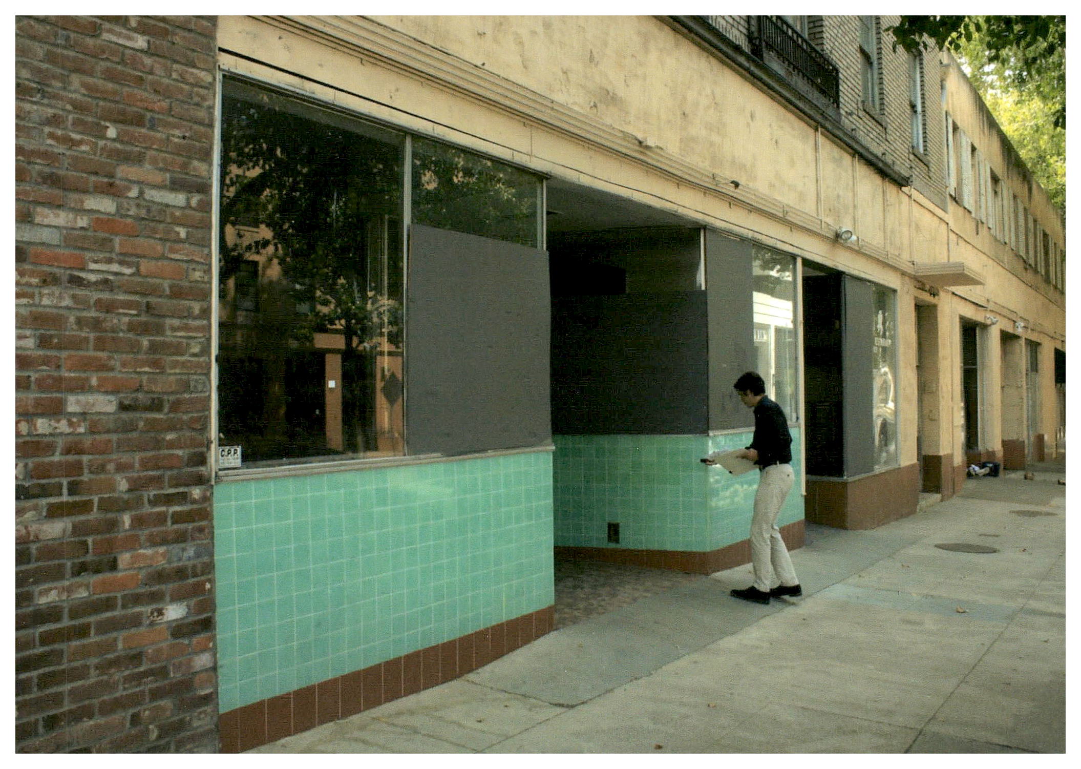 Before: sidewalk view of existing non-original storefronts.